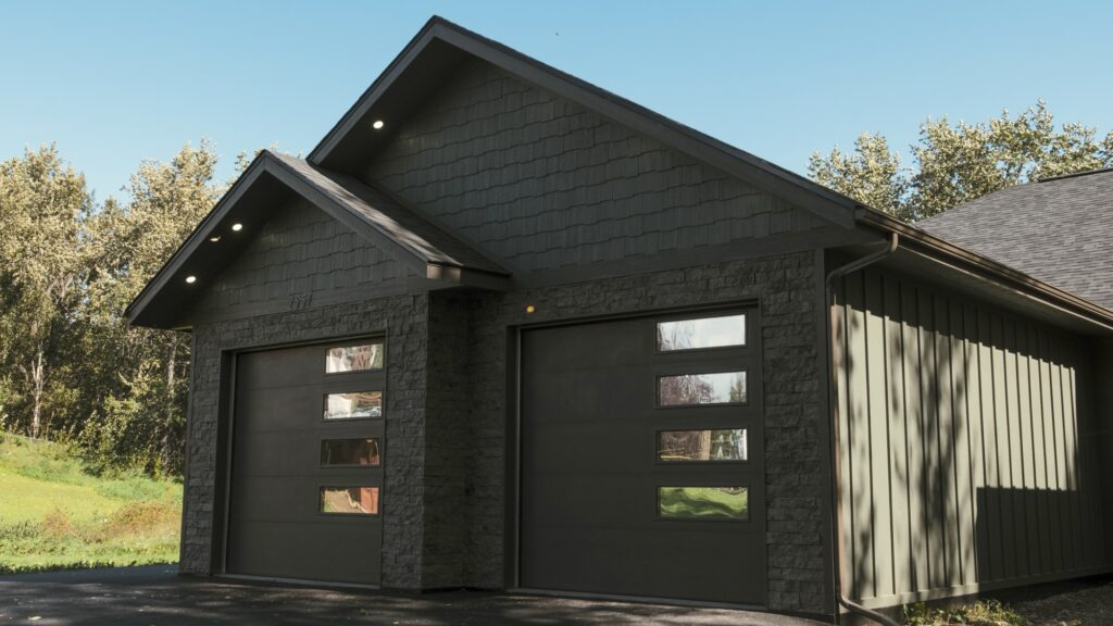 Alpenglow Builders LLC - Alpenglow Builders LLC luxury custom home in Palmer, Alaska, showcasing modern black exterior with sleek garage doors and con.