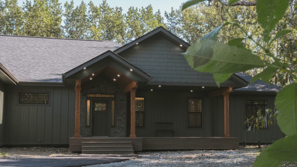 Alpenglow Builders LLC - Alpenglow Builders LLC luxury custom home in Palmer, Alaska with modern black exterior, wooden accents, and spacious front po.