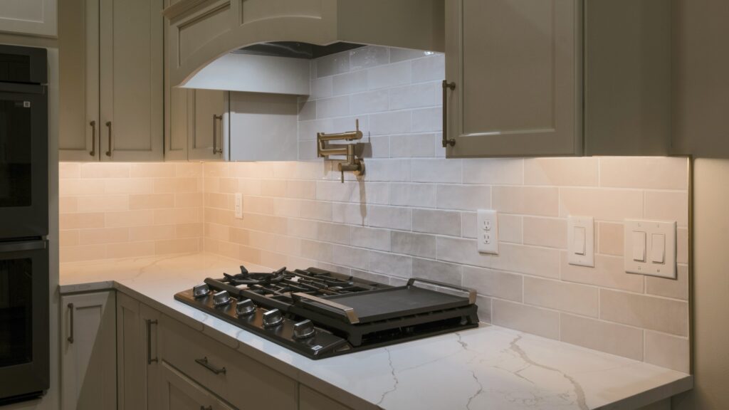 Alpenglow Builders LLC - Alpenglow Builders LLC luxury kitchen with modern cabinetry, white tile backsplash, and built-in gas stove in Palmer, Alaska.