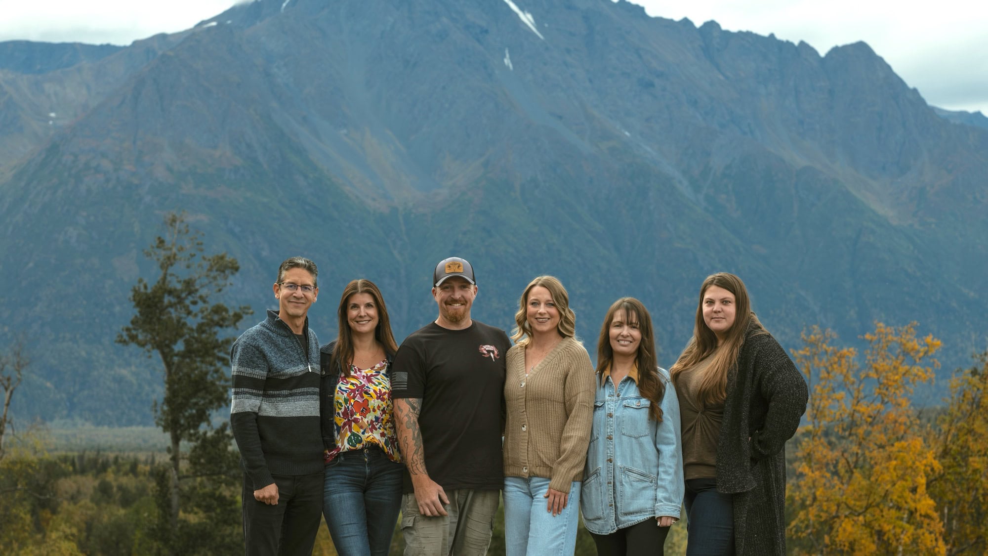 Alpenglow Builders LLC - Alpenglow Builders luxury home team in Palmer, Alaska, with mountain backdrop, showcasing custom architectural craftsmanship.