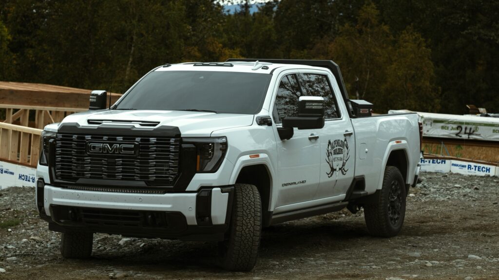Alpenglow Builders LLC - High-end custom luxury home construction site in Palmer, Alaska, featuring a GMC truck with Alpenglow Builders logo, professi.